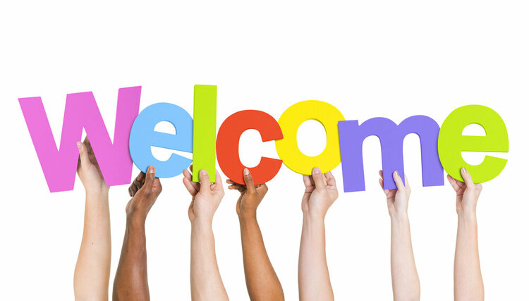 Ausgestreckte Arme und Hände in unterschiedlichen Hautfarben, die das Wort "Welcome" in bunten Buchstaben hochhalten.