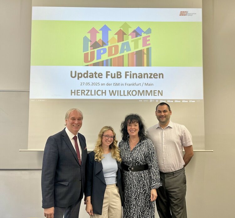 Heinrich Geusken, Elisabeth Körbel, Vivian Stolle und René Sonnefeld stehen vor der Präsentation der Veranstaltung mit dem Titel "Update FuB Finanzen" am 27.05.2025 an der ISM in Frankfurt/Main und der Begrüßung "HERZLICH WILLKOMMEN".
