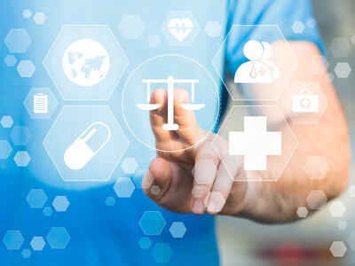 Eine Hand berührt ein virtuelles Interface, das verschiedene Symbole im Zusammenhang mit dem Gesundheitswesen zeigt, darunter eine Waage, eine Pille, ein medizinisches Kreuz, ein EKG-Symbol, eine Krankenakte und ein Globus. Die Symbole sind in hexagonale Felder eingebettet und scheinen Teil eines digitalen Netzwerks oder Systems zu sein.