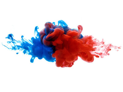 Eine abstrakte Darstellung von zwei sich vermischenden Flüssigkeiten in den Farben Blau und Rot. Die Flüssigkeiten scheinen in Bewegung zu sein und bilden eine dynamische, fast explosive Form. Der Hintergrund ist weiß, was die Farben der Flüssigkeiten hervorhebt.