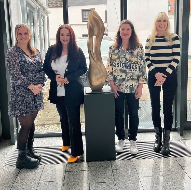 Vier Mitarbeiterinnen stehen im Foyer der ESO Education Group und blicken in die Kamera