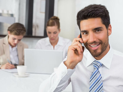 Drei Personen nehmen an einem Meeting teil. Die professionelle Interaktion steht im Vordergrund.