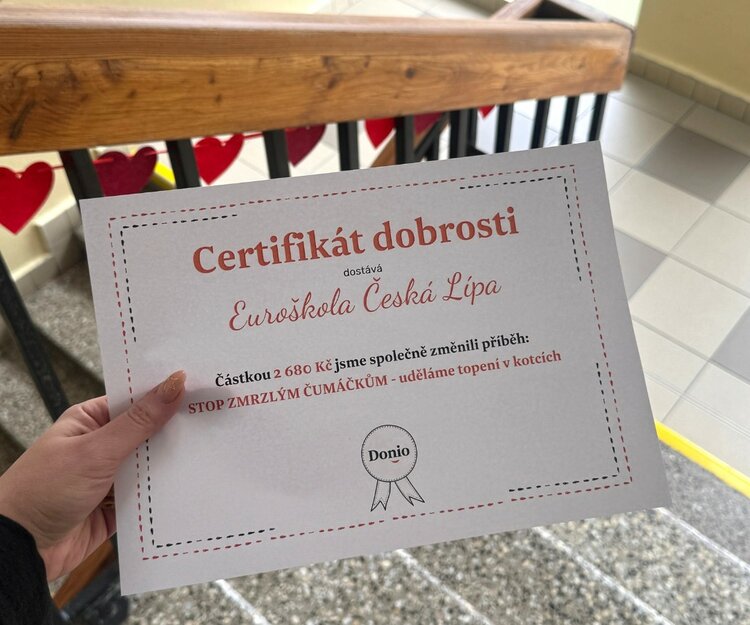 Eine Hand hält ein Zertifikat mit der Aufschrift "Certifikát dobrosti" für Euroškola Česká Lípa. Der Text auf dem Zertifikat besagt, dass eine Person 2.680 Kronen gespendet hat.