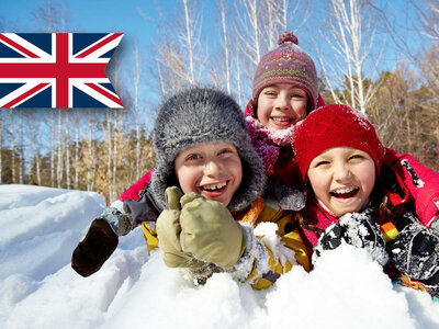 Drei Kinder spielen im Schnee, mit Winterkleidung und UK-Flagge im Hintergrund. 