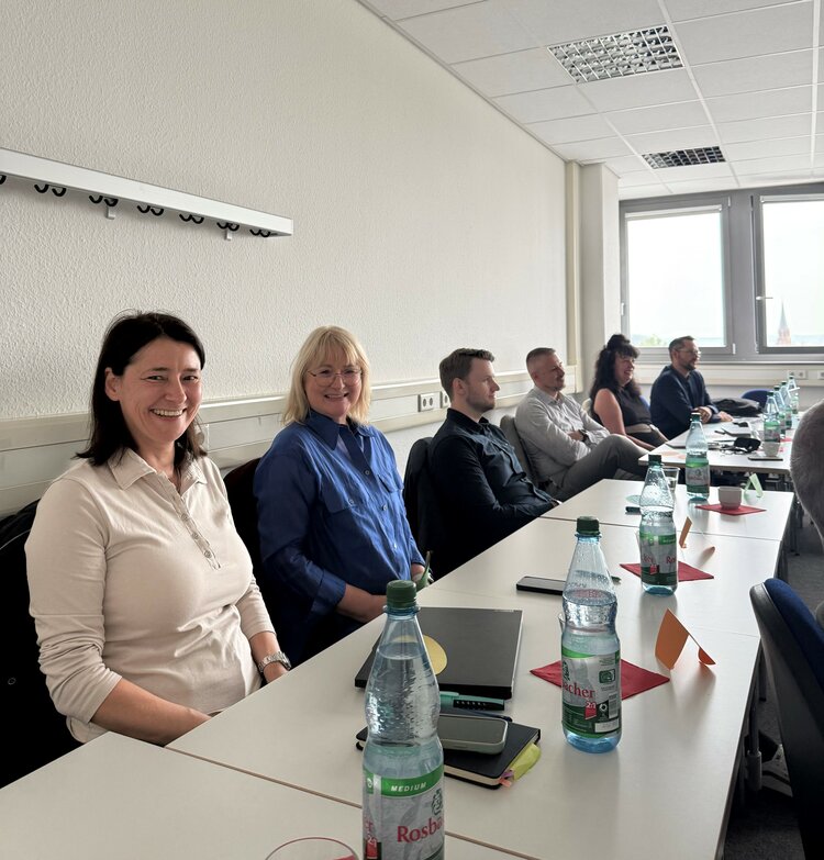 Kommunikation als Schlüssel nachhaltiger Führung Seminarteilnehmende sitzen an Tischen in einem Klassenraum.