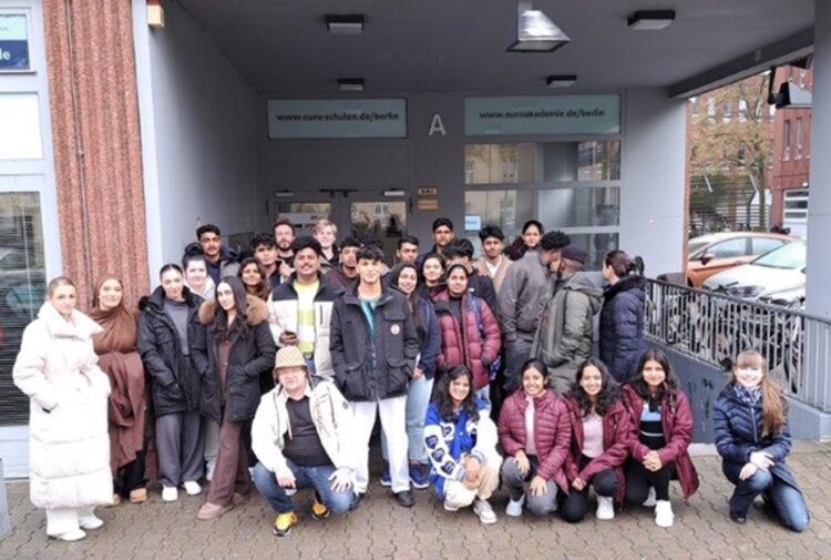 Auszubildende zu Pflegeassistentinnen und -Assistenten posieren draußen für ein Klassenfoto.